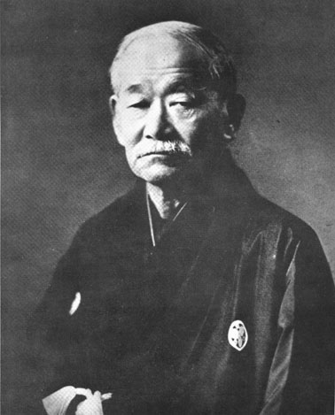 Kanō Jigorō im Alter: Porträt eines Mannes mit kurzem weissem Haar und Schnurrbart im dunklen Kimono, Schwarz-Weiss-Foto.