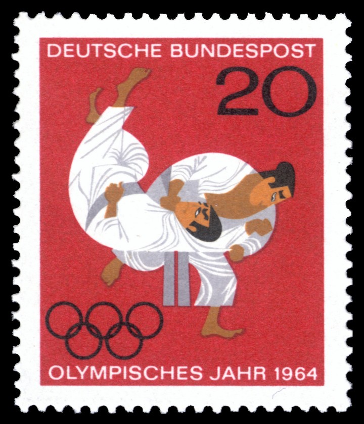 Briefmarke der Deutschen Bundespost «Olympisches Jahr 1964»: zwei Judoka bei einem Wurf, darunter die olympischen Ringe, auf rotem Grund.